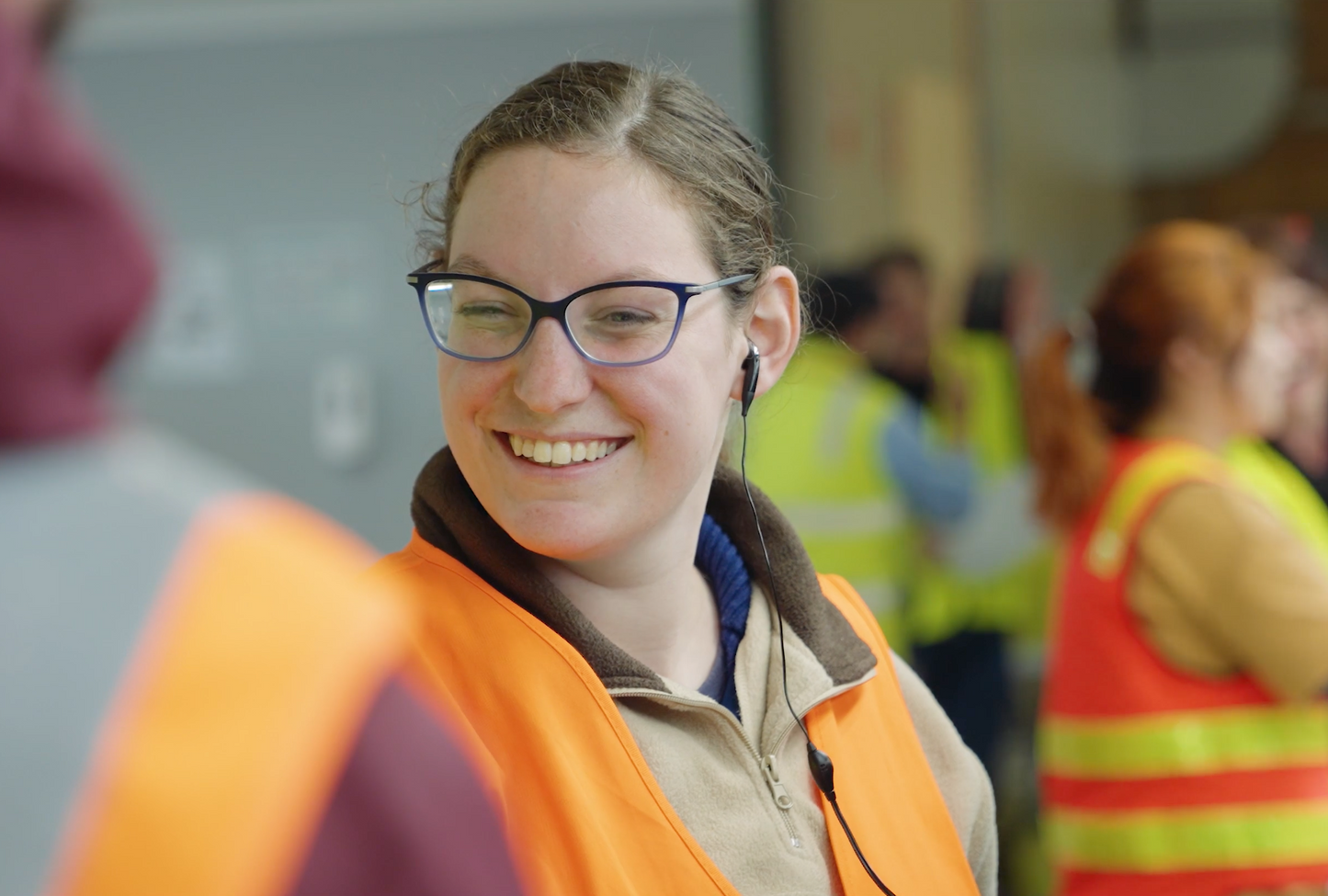 Koala Cherries employee smiling in high vis with radio in ear